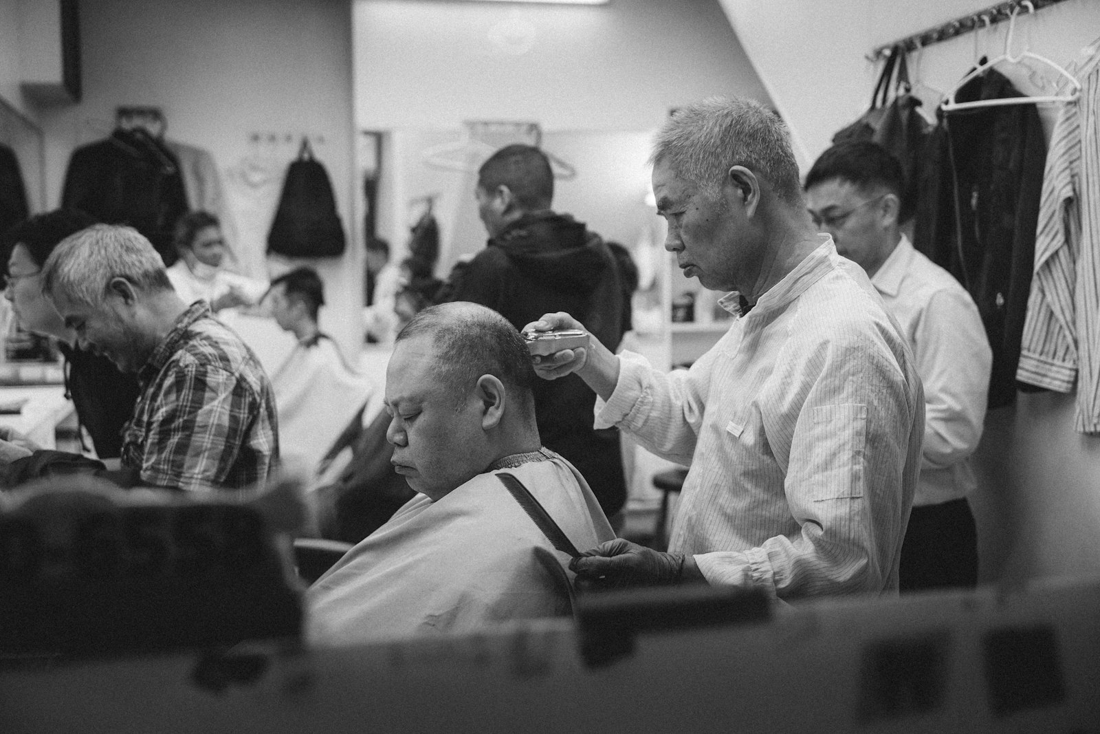 Ein Friseur stylt das Haar einer Kundin im Salon