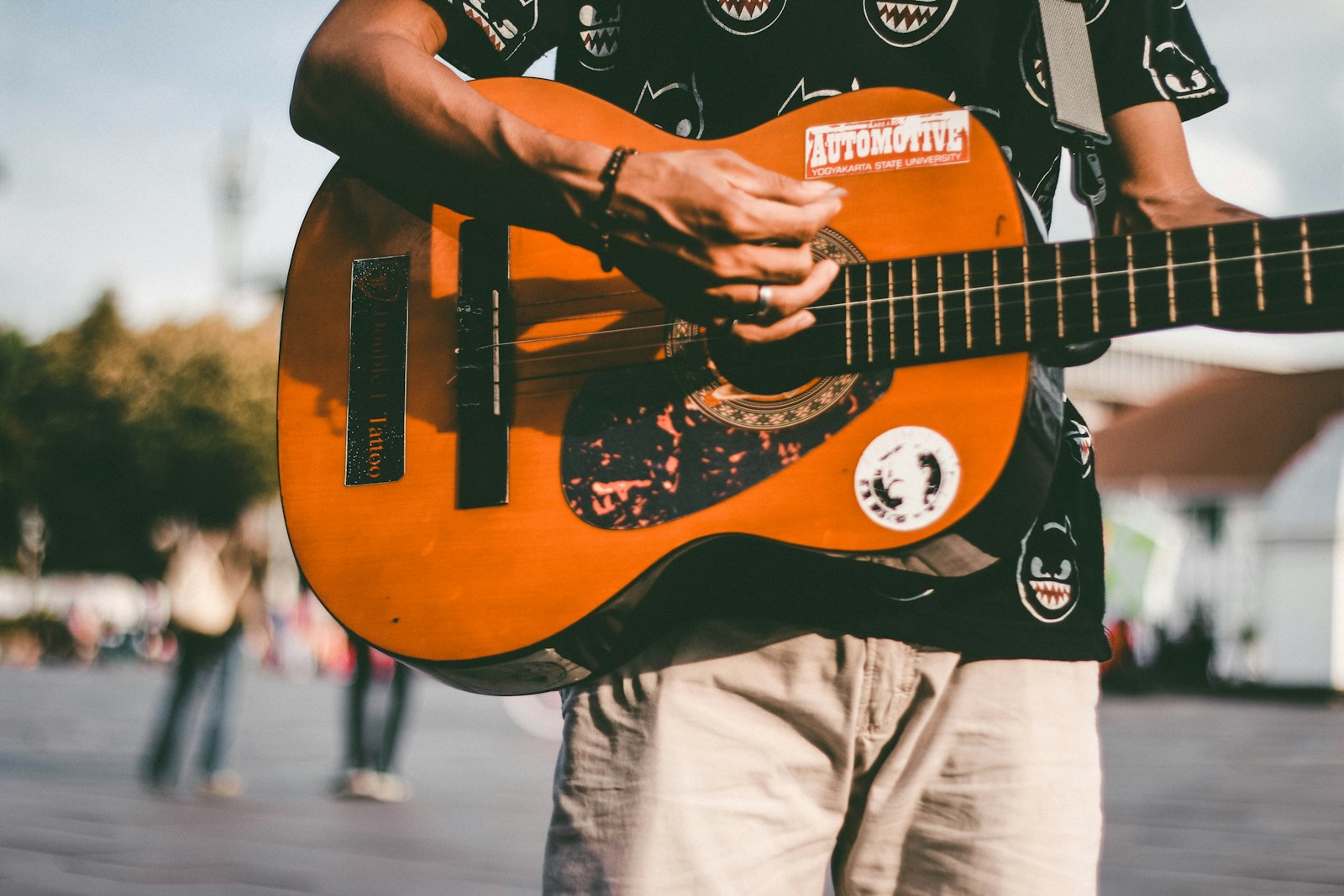 Ein Straßenmusiker spielt Gitarre vor Passant:innen